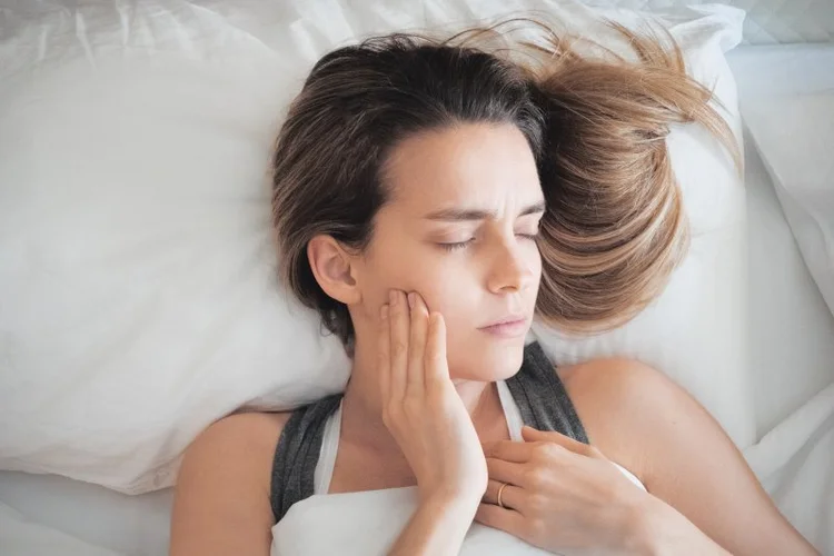 A picture of a lady sleeping with toothache